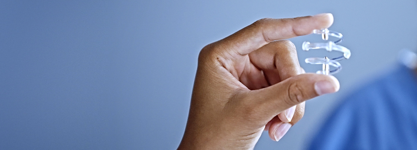 Close up of hand holding marker in a lab setting.