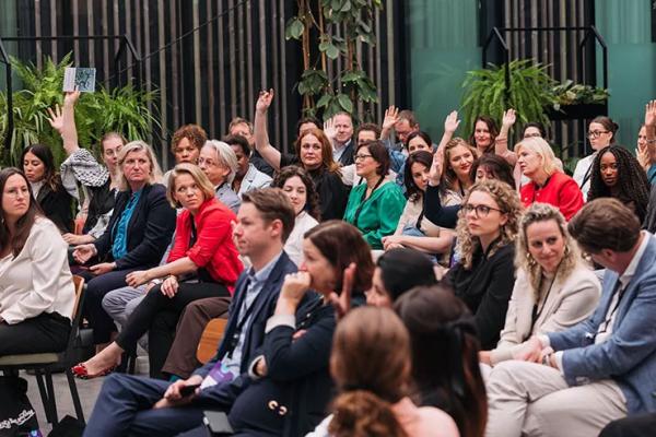 Interior photo of audience members at forum in Netherlands