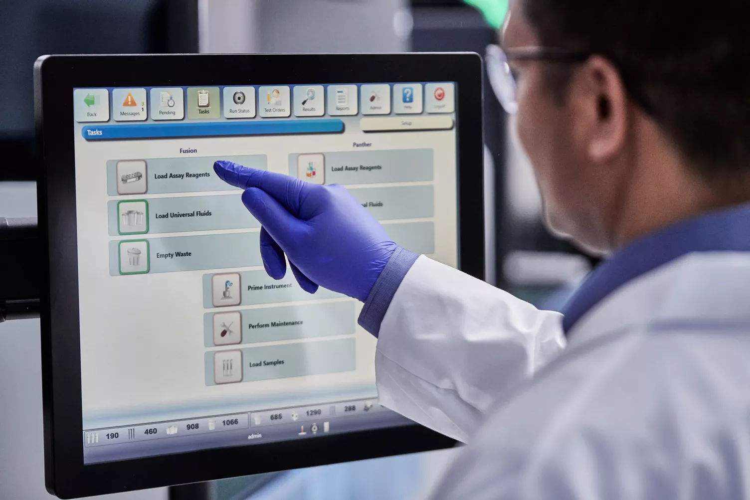 Lab technician pressing buttons on monitor