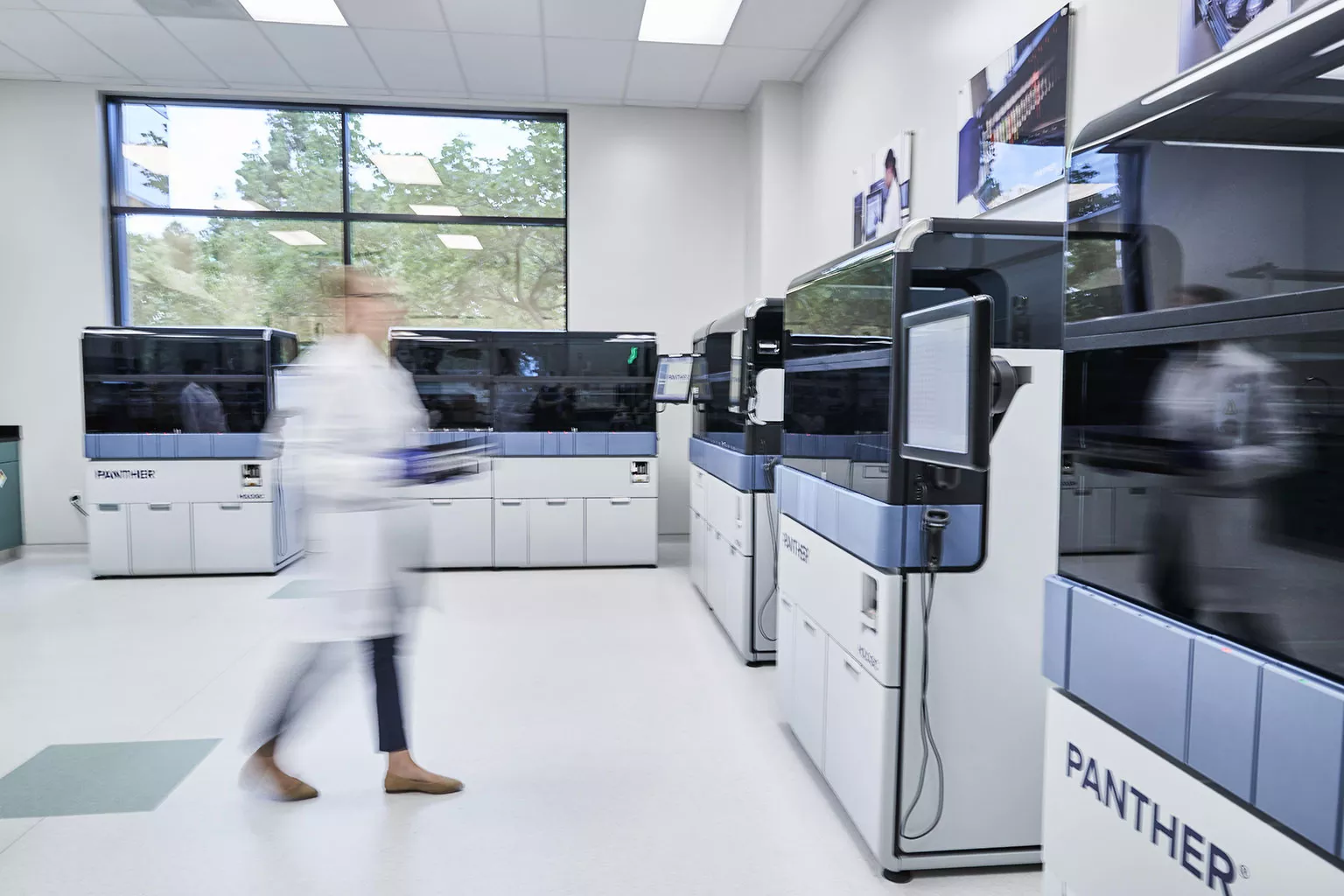 Female technician walks through lab setting.