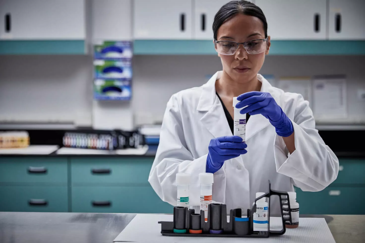 Lab technician holding onto swab collection kit in lab setting